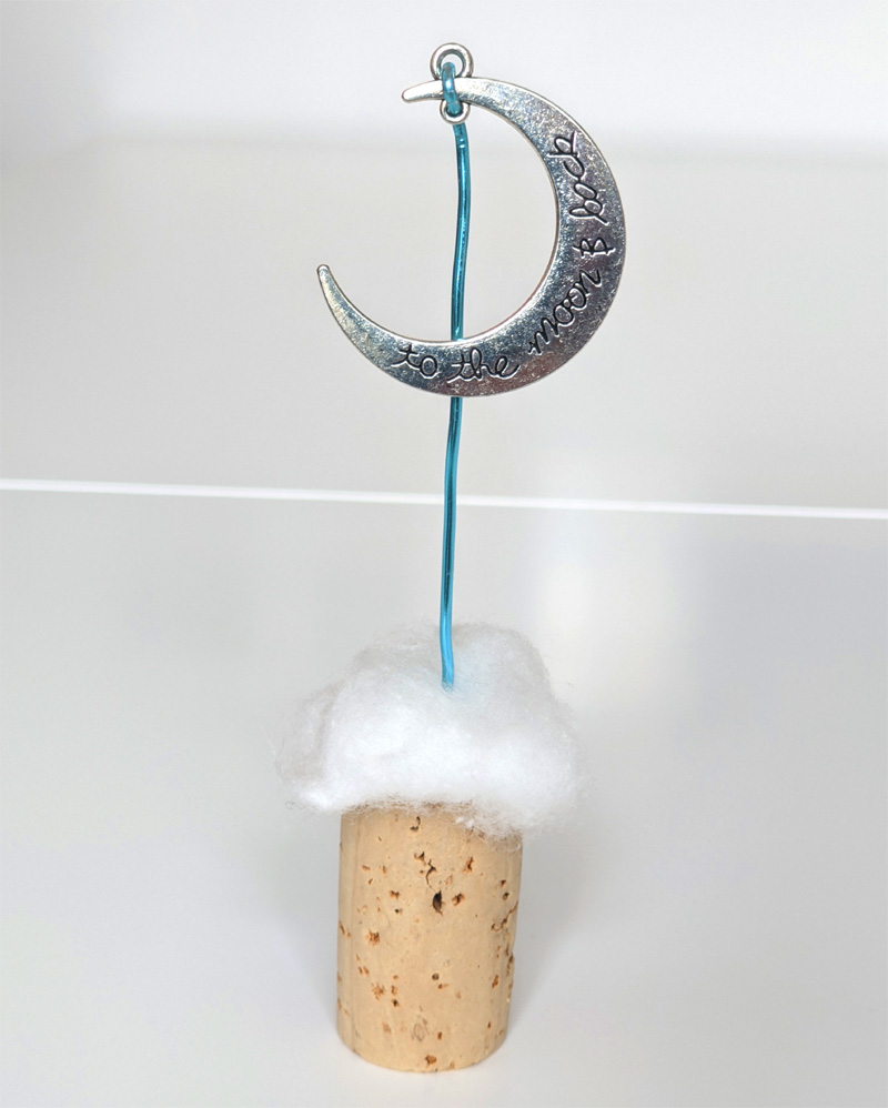 Anhänger silbermond mit aufschrift 'to the moon and back' am draht auf naturkorken